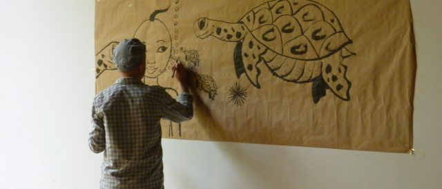 Artiste dessinant un fresque au Centre Culturel Français Denis Masson